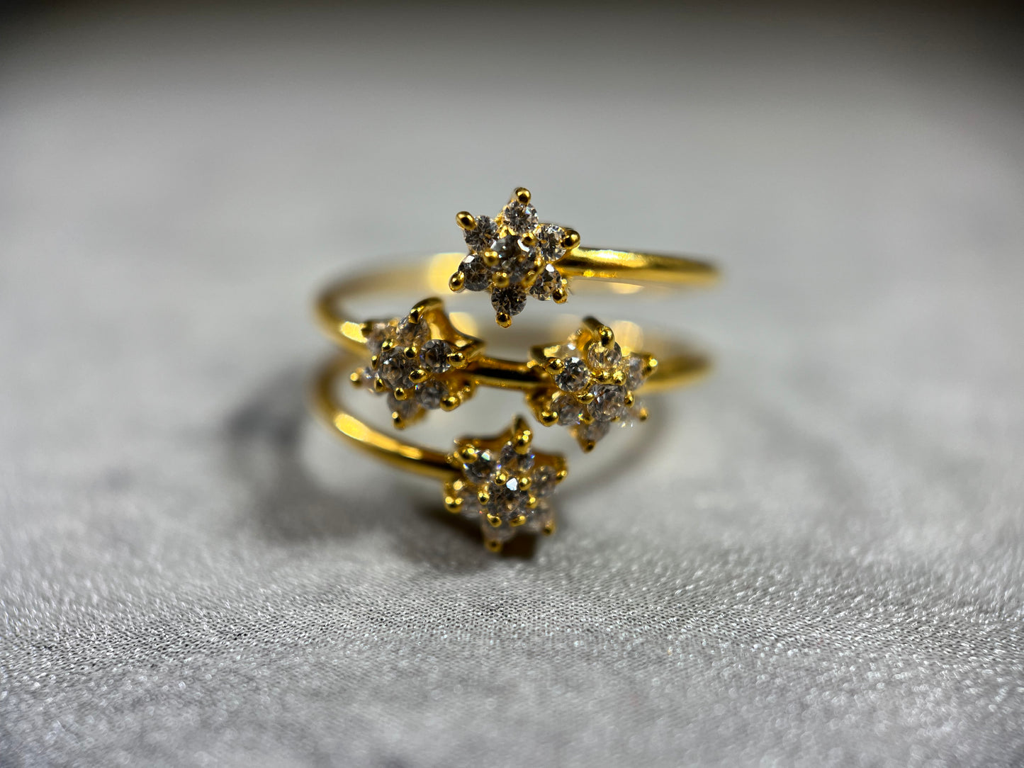 This elegant Gold Triple Wire Ring, featuring a stunning flower design with four radiant gemstones in a flower design. Crafted from 22K gold, this masterpiece exudes sophistication and grace. The intertwined bands ensure a comfortable fit for any occasion. Elevate your style with the timeless beauty of nature and the brilliance of gemstones in this unique and exquisite ring!