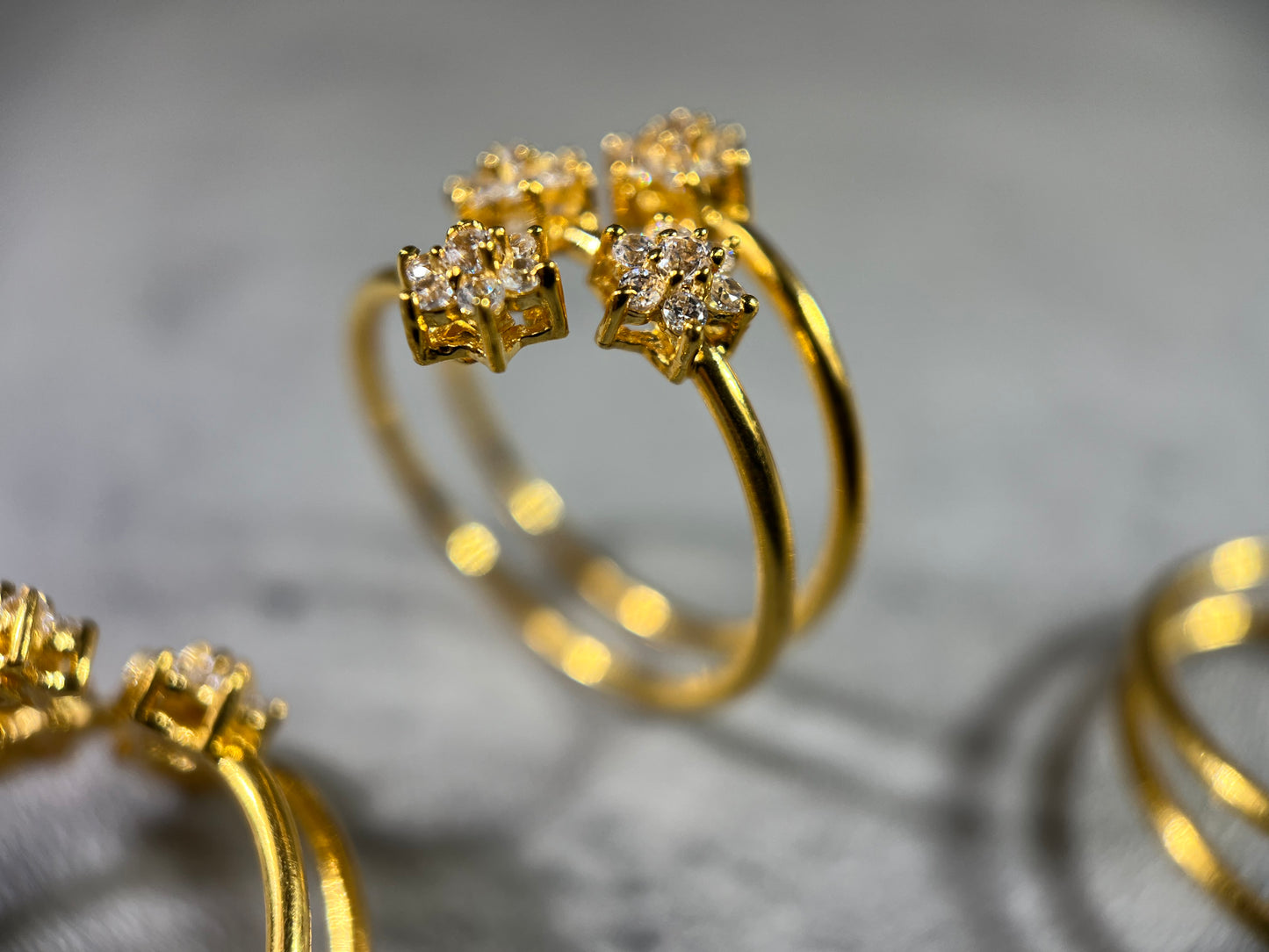 This elegant Gold Triple Wire Ring, featuring a stunning flower design with four radiant gemstones in a flower design. Crafted from 22K gold, this masterpiece exudes sophistication and grace. The intertwined bands ensure a comfortable fit for any occasion. Elevate your style with the timeless beauty of nature and the brilliance of gemstones in this unique and exquisite ring!