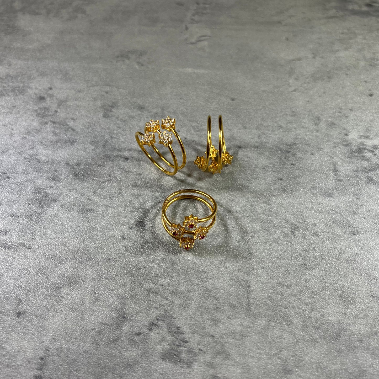 This elegant Gold Triple Wire Ring, featuring a stunning flower design with four radiant gemstones in a flower design. Crafted from 22K gold, this masterpiece exudes sophistication and grace. The intertwined bands ensure a comfortable fit for any occasion. Elevate your style with the timeless beauty of nature and the brilliance of gemstones in this unique and exquisite ring!