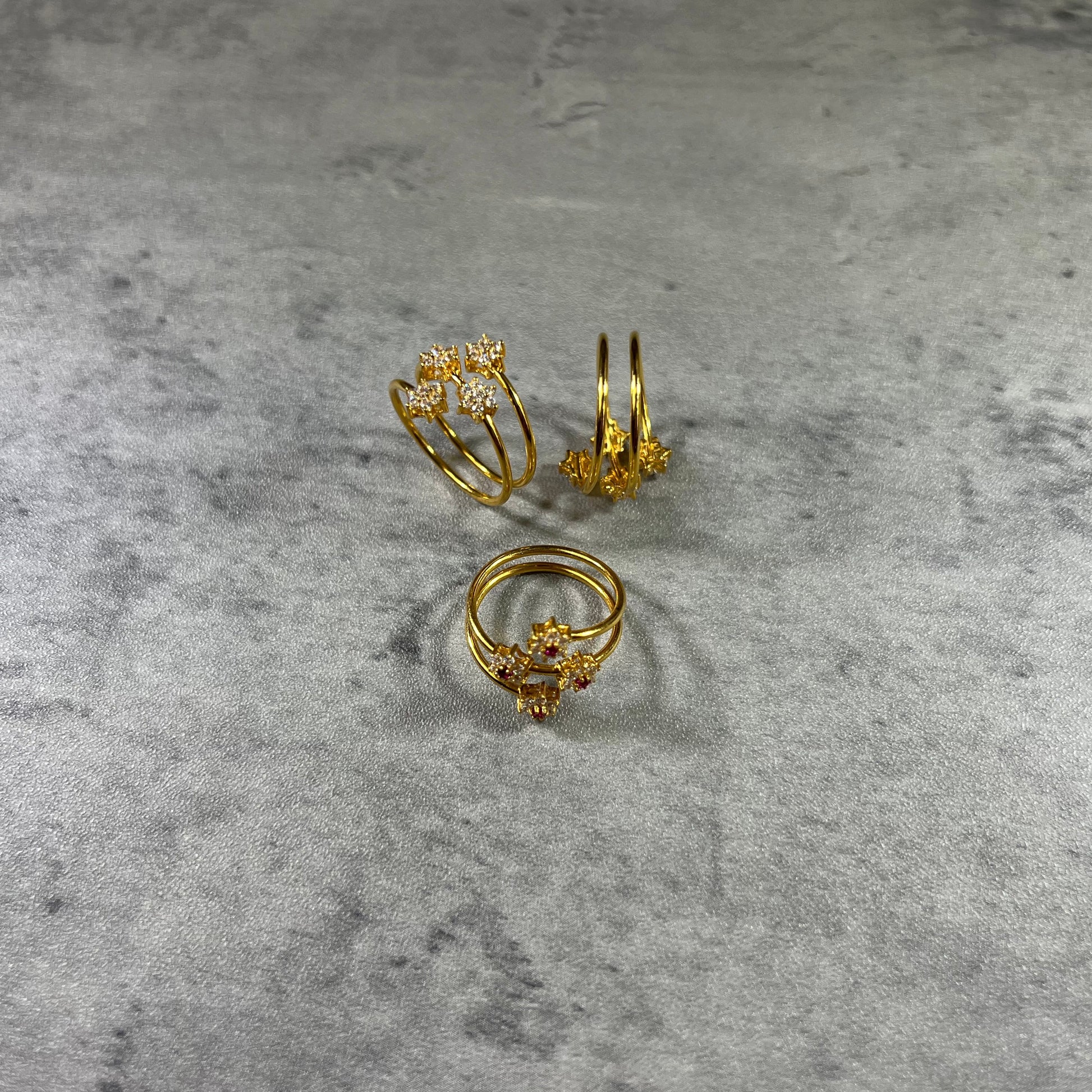 This elegant Gold Triple Wire Ring, featuring a stunning flower design with four radiant gemstones in a flower design. Crafted from 22K gold, this masterpiece exudes sophistication and grace. The intertwined bands ensure a comfortable fit for any occasion. Elevate your style with the timeless beauty of nature and the brilliance of gemstones in this unique and exquisite ring!