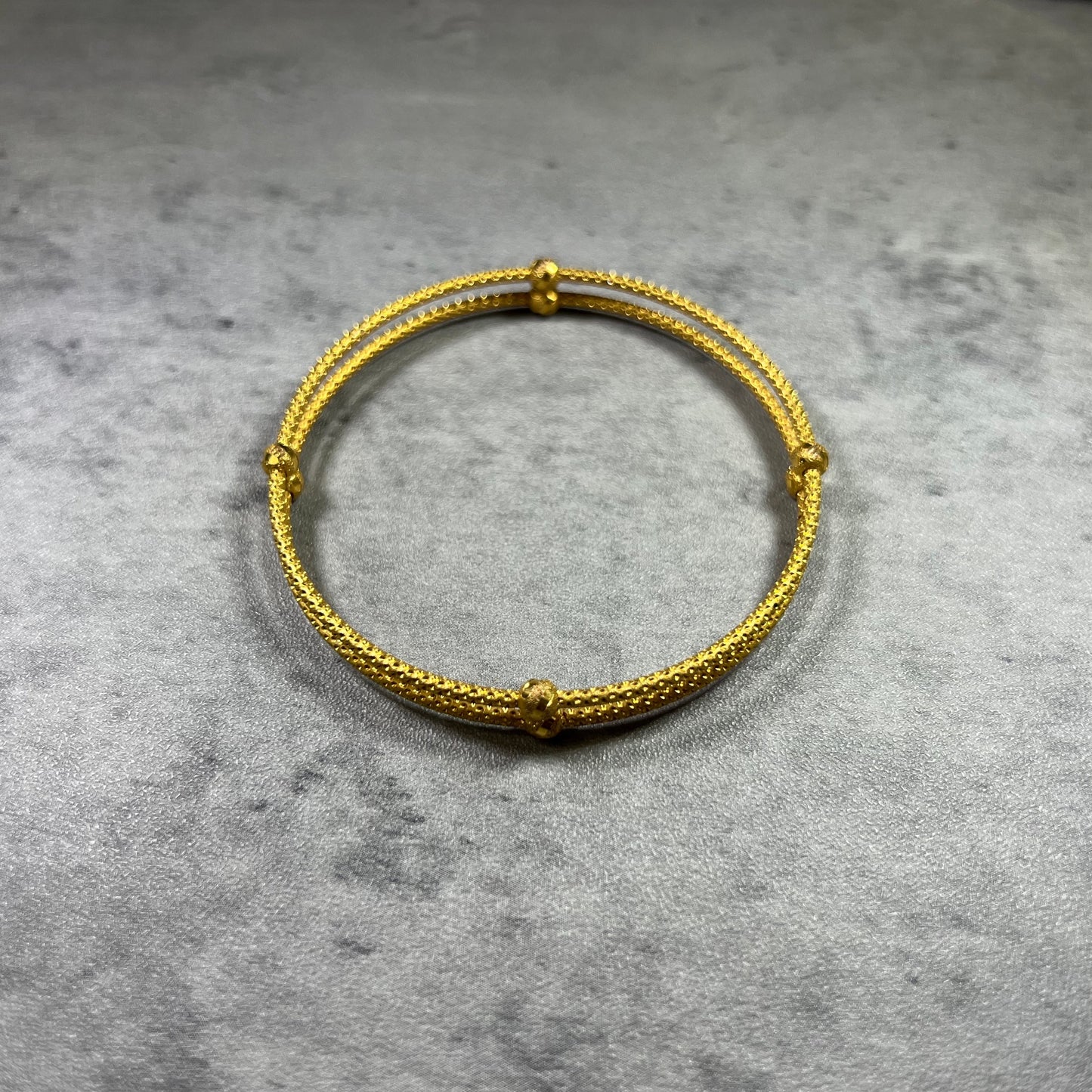 our stunning 22ct Yellow Gold Hallmarked Double Joined Bangle—an exquisite blend of craftsmanship. Its intricately hand-carved design and highly polished finish exude sophistication. With a comfortable 6cm diameter and a sleek 1.8cm width, it complements any outfit. Each bangle comes with elegant gift packaging, making it a perfect choice for yourself or a loved one. Elevate your style with this beautifully crafted gold bangle—a true symbol of timeless elegance.