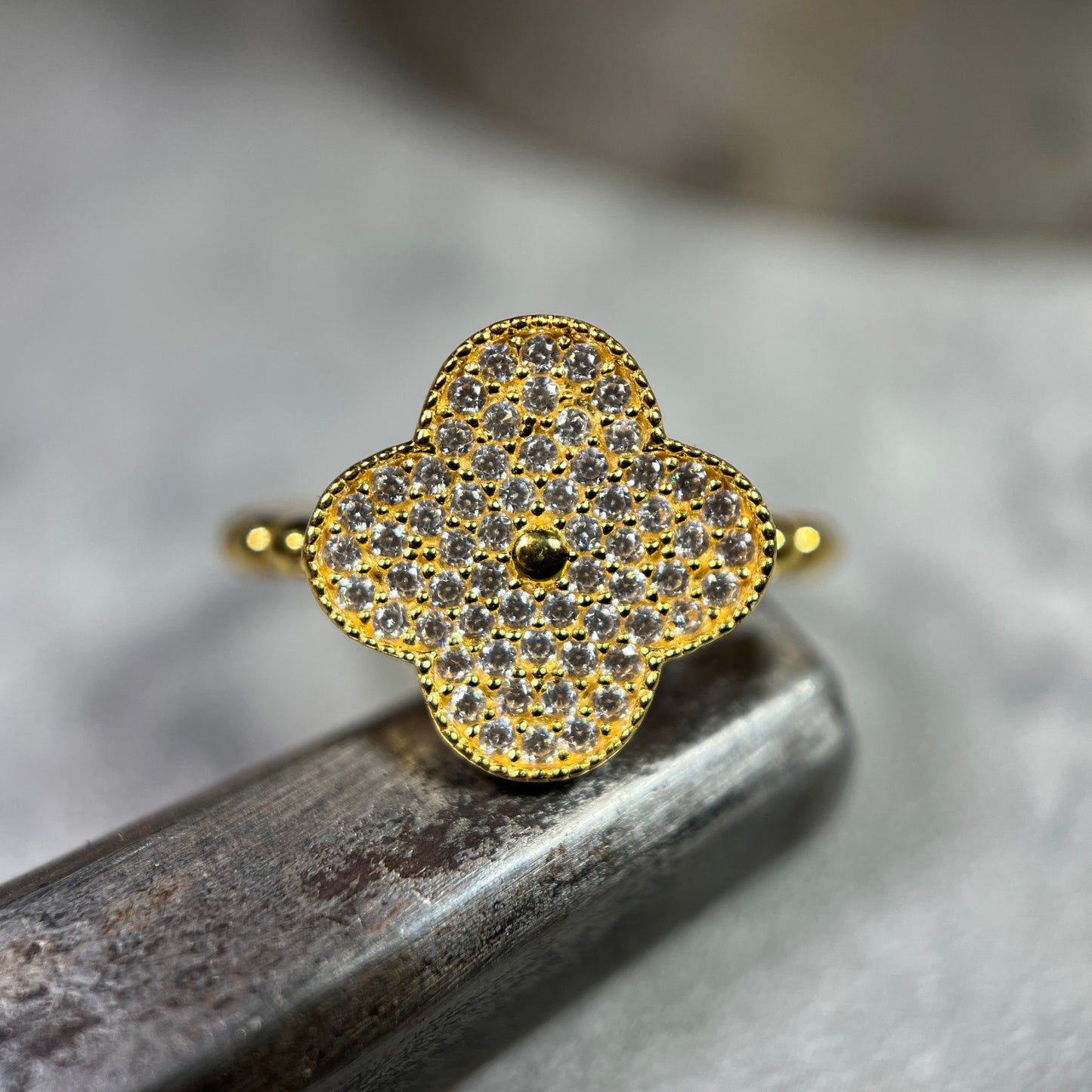 Handmade 22ct Clover ring adorned with handpicked cubic zirconia, featuring a ball band with adjustable sizing. Explore artisan craftsmanship and timeless elegance